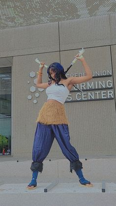 a woman dressed in costume is holding two tennis racquets