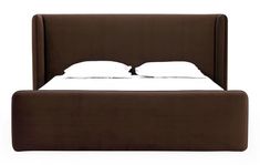 a bed with two white pillows on top of it and a headboard made out of brown fabric