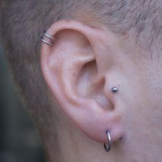 a close up of a persons ear with two piercings on it's sides