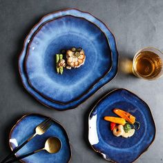 three blue plates with different types of food on them, one has broccoli and the other has carrots