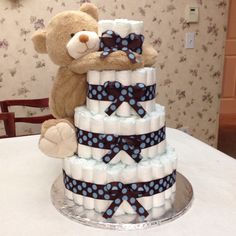 a teddy bear sitting on top of a diaper cake