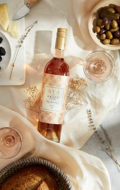 a bottle of wine sitting next to a muffin on a table with other food