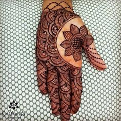 a henna tattoo on someone's hand that is decorated with circles and flowers