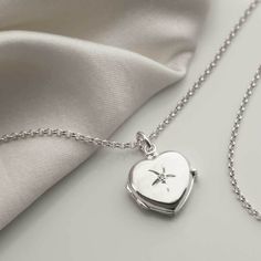 "Our beautiful Sterling Silver diamond Kissed Locket has a wonderfully classic design making it a timeless piece which will be loved and treasured for years to come. The front of the locket is embellished with a single round cut diamond and the back has a luxurious plain polished surface, perfect for engraving a message on. In addition, this locket is designed to hold two photos. This locket comes complete with a sterling silver belcher chain available in five different lengths. So why not make this a truly personal gift by having your own special message engraved, by us, on this eye catching locket. To order this locket simply select the chain length and the font you would like us to use from the drop down menu, you can select \"no engraving\" if you would like us to leave it blank. Then Keepsake Diamond Necklace In White Gold, Elegant Medallion Locket Necklace For Valentine's Day, Keepsake White Gold Diamond Necklace, Elegant Diamond Locket Necklace, Diamond Pendant Necklace For Keepsake, Elegant Locket Necklace For Valentine's Day Anniversary, Fine Jewelry Locket Necklace For Anniversary, Fine Jewelry Wedding Locket, Elegant Heart Pendant Locket Necklace For Anniversary