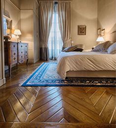 a large bed sitting inside of a bedroom on top of a wooden floor