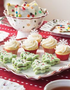 cupcakes and cookies are on a plate next to a bowl full of candy