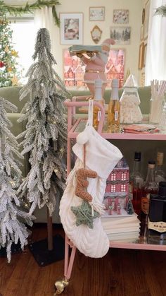 two christmas trees are next to each other on a shelf in front of a couch