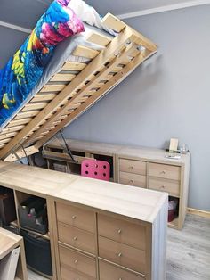 a loft bed with drawers underneath it and a desk in the corner next to it