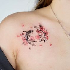 a woman's chest with two koi fish and flowers on it