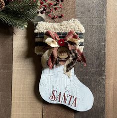 a christmas stocking hanging on a wooden wall with the word santa written on it