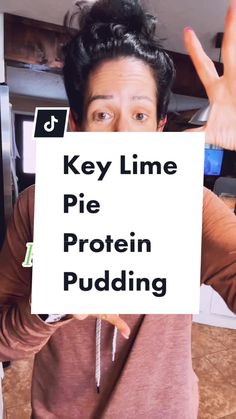 a man holding up a sign with the words key lime pie protein pudding on it