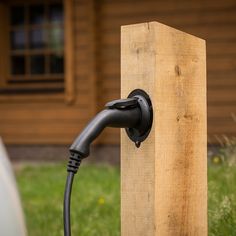 a black hose connected to a wooden post