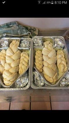 two metal trays filled with food on top of a table