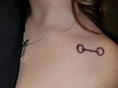 a woman with a tattoo on her chest holding a pair of scissors in the shape of a key