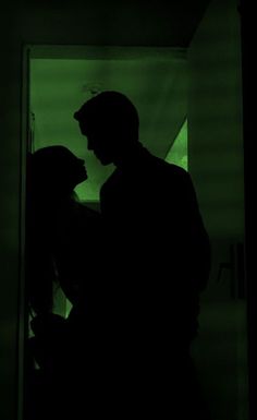 a man and woman standing next to each other in the dark