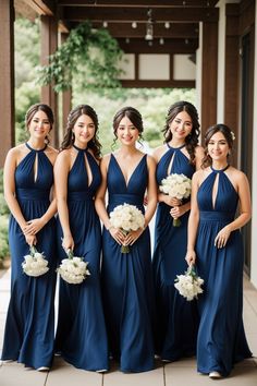 a group of women standing next to each other wearing blue dresses and holding bouquets