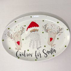 an oval platter decorated with handprinted christmas cookies for santa and reindeers