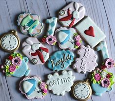 decorated cookies are arranged on a wooden surface with the words hello kitty and other decorations