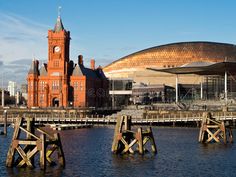 a large building with a clock tower next to a body of water