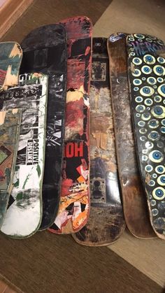 five skateboards are lined up in a row on the floor next to each other