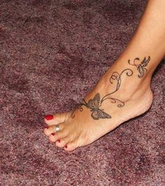 a woman's foot with a butterfly tattoo on it