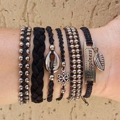 a woman's arm with four different bracelets on top of each other,