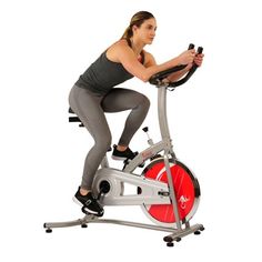 a woman is riding an exercise bike on a white background with red and black accents