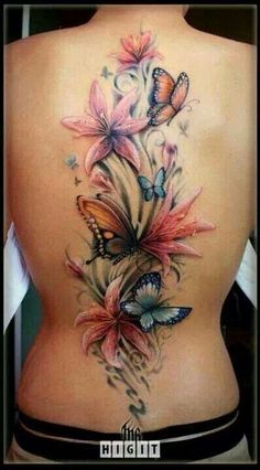 the back of a woman's body with butterflies on it and flowers in the middle