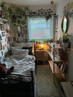 a bed room with a neatly made bed and lots of pictures on the wall behind it