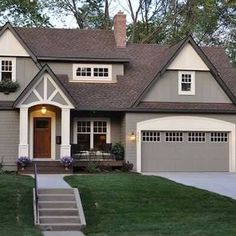 a gray house with white trim and brown roof