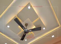 a ceiling fan mounted to the ceiling in a room with white walls and lights on it