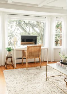 a living room filled with furniture and a flat screen tv sitting on top of a wooden table