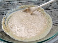 a glass bowl filled with batter on top of a wooden table