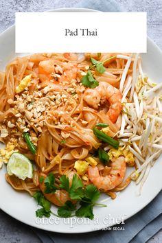 pad thai noodles with shrimp and vegetables on a white plate