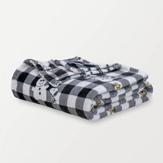 two black and white checkered blankets folded on top of each other, one with a teddy bear