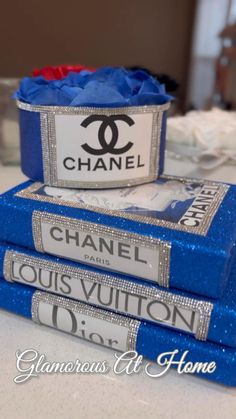 three chanel books stacked on top of each other in front of a table with flowers