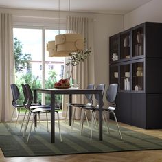 a dining room table and chairs in front of a window