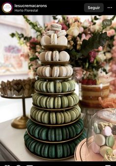 a stack of macaroons sitting on top of a table next to other desserts