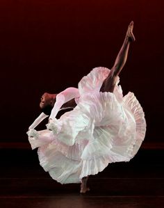 a woman in a white dress is dancing