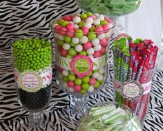 a table topped with lots of candy and candies next to glasses filled with lollipops