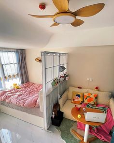 a room with a bed, desk and ceiling fan in it's corner area