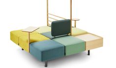 a multicolored couch with a wooden frame and footrests on the back