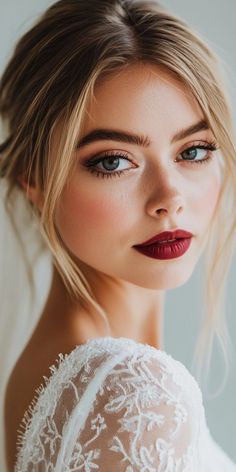 a woman with blue eyes and red lipstick is wearing a white lace dress, looking into the distance