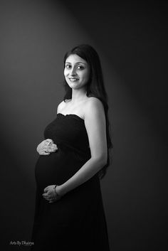 a pregnant woman poses for a black and white photo