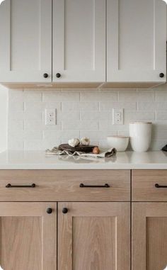 a white kitchen with wooden cabinets and counter tops