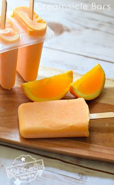 popsicles with orange slices and ice cream on a cutting board