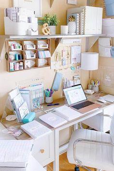 a desk with a laptop computer sitting on top of it next to a chair and lamp