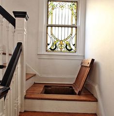 an open toilet sitting on the floor in front of a window next to some stairs