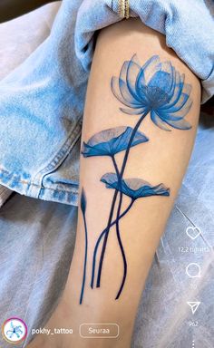 a woman's arm with blue water lilies tattoo on her left forearm and leg