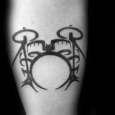 a black and white photo of a drummer's drum set tattoo on the leg